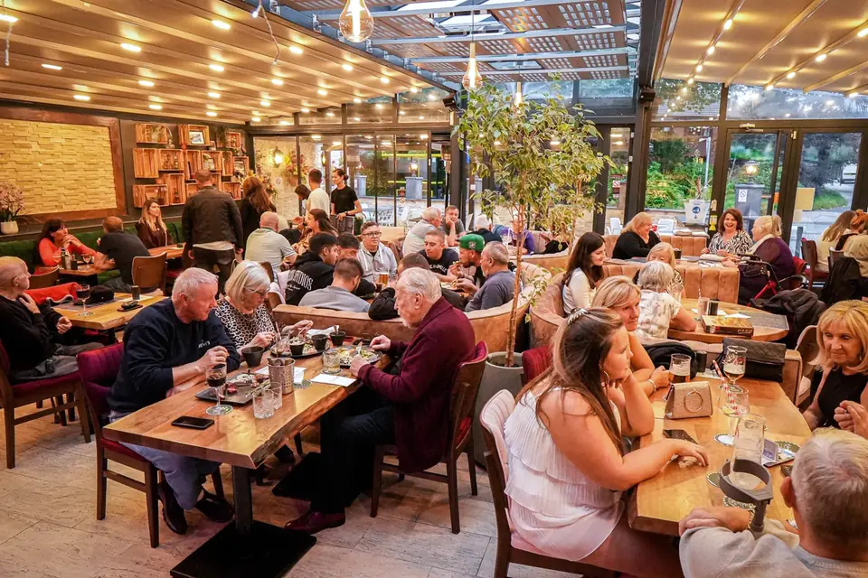 A full conservatory dining room at Al Dente under a glass roof and warm lights