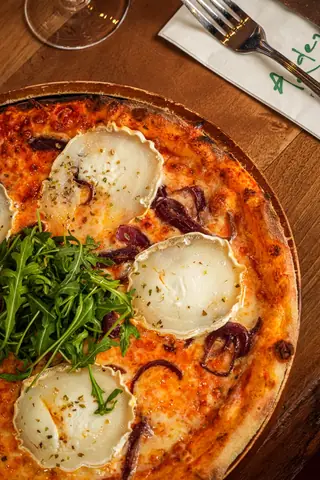 Fire-oven pizza with goat’s cheese, red onion and rocket