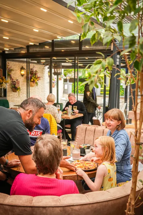 A family sharing a pepperoni pizza at Al Dente